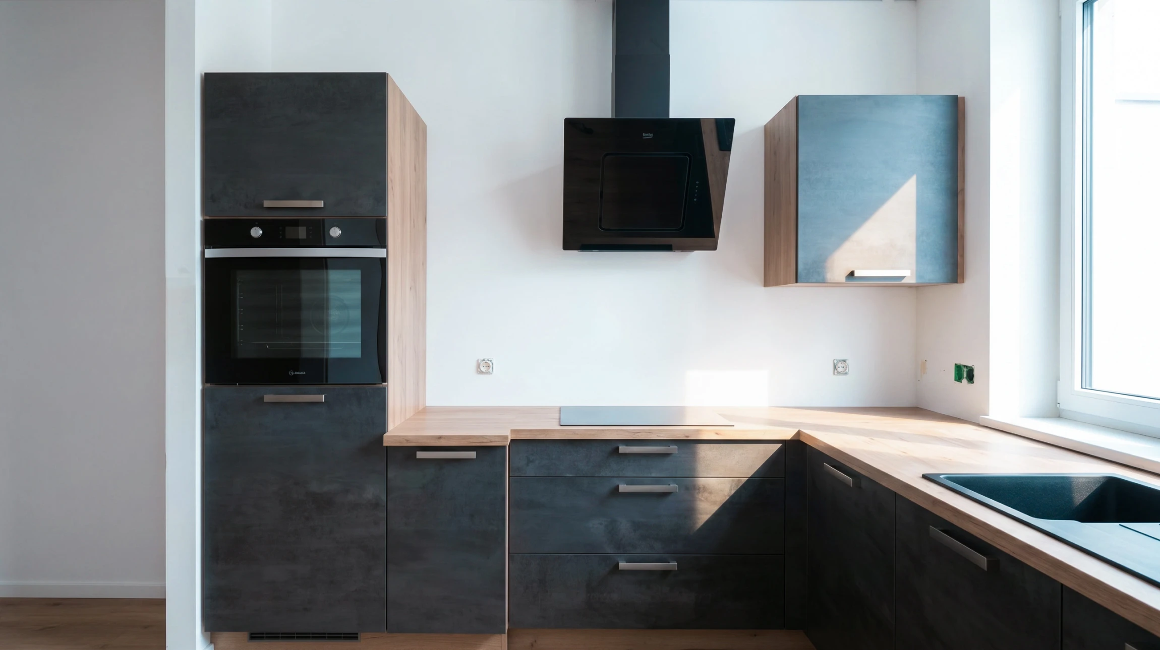 Cuisine moderne minimaliste avec façades grises mat, plan de travail en stratifié, crédence mosaïque dorée rétro-éclairée